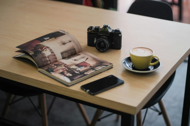 a table with a coffee cup and magazines