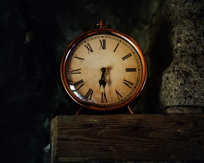 an old fashioned clock sits on top of a wooden shelf