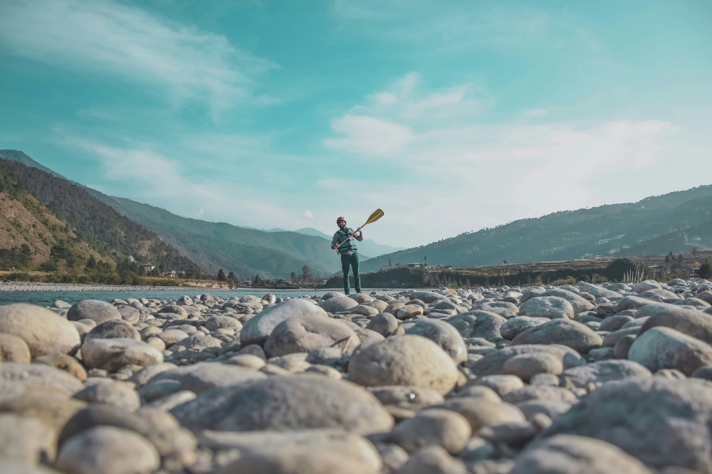 a man is standing on rocks on the water