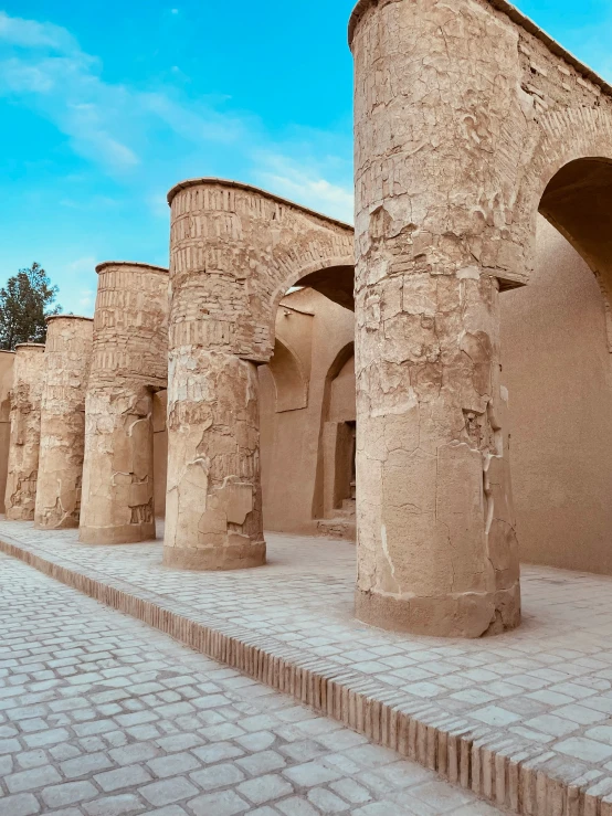 a brick walkway lined with pillars in an ancient city