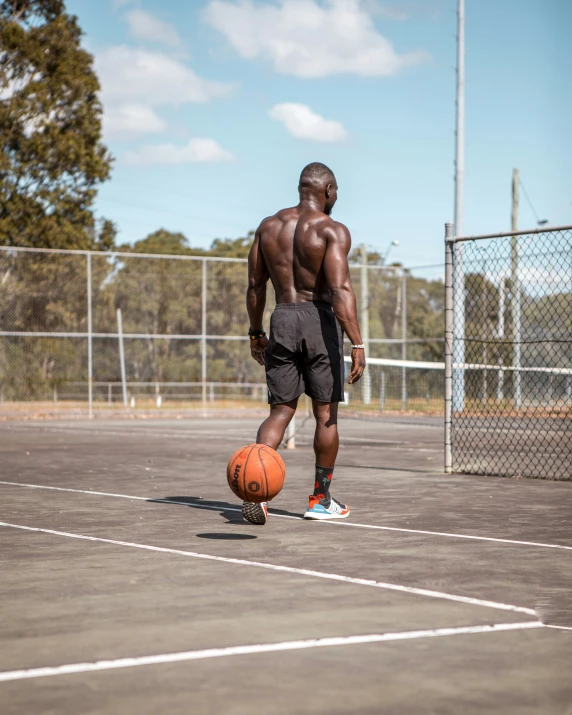 a man with  on dribbling a basketball