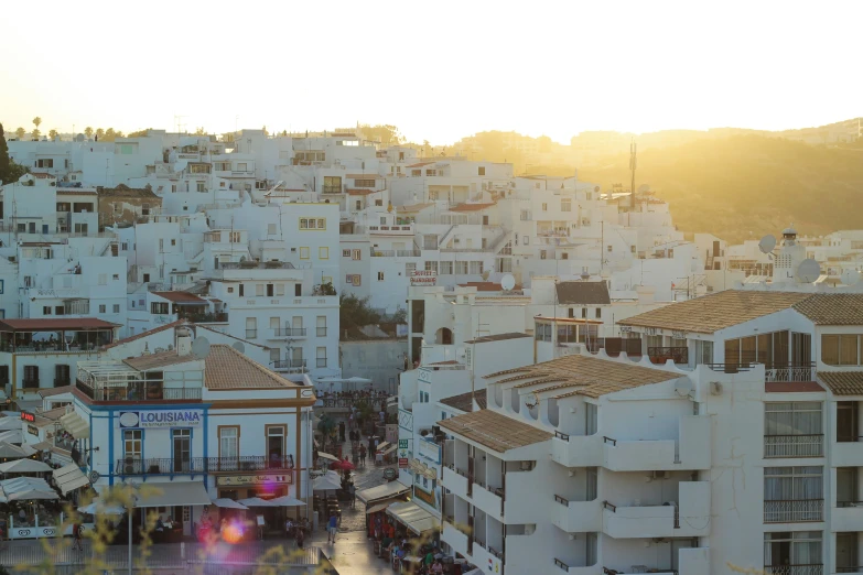 a view of the sun shining on some white buildings