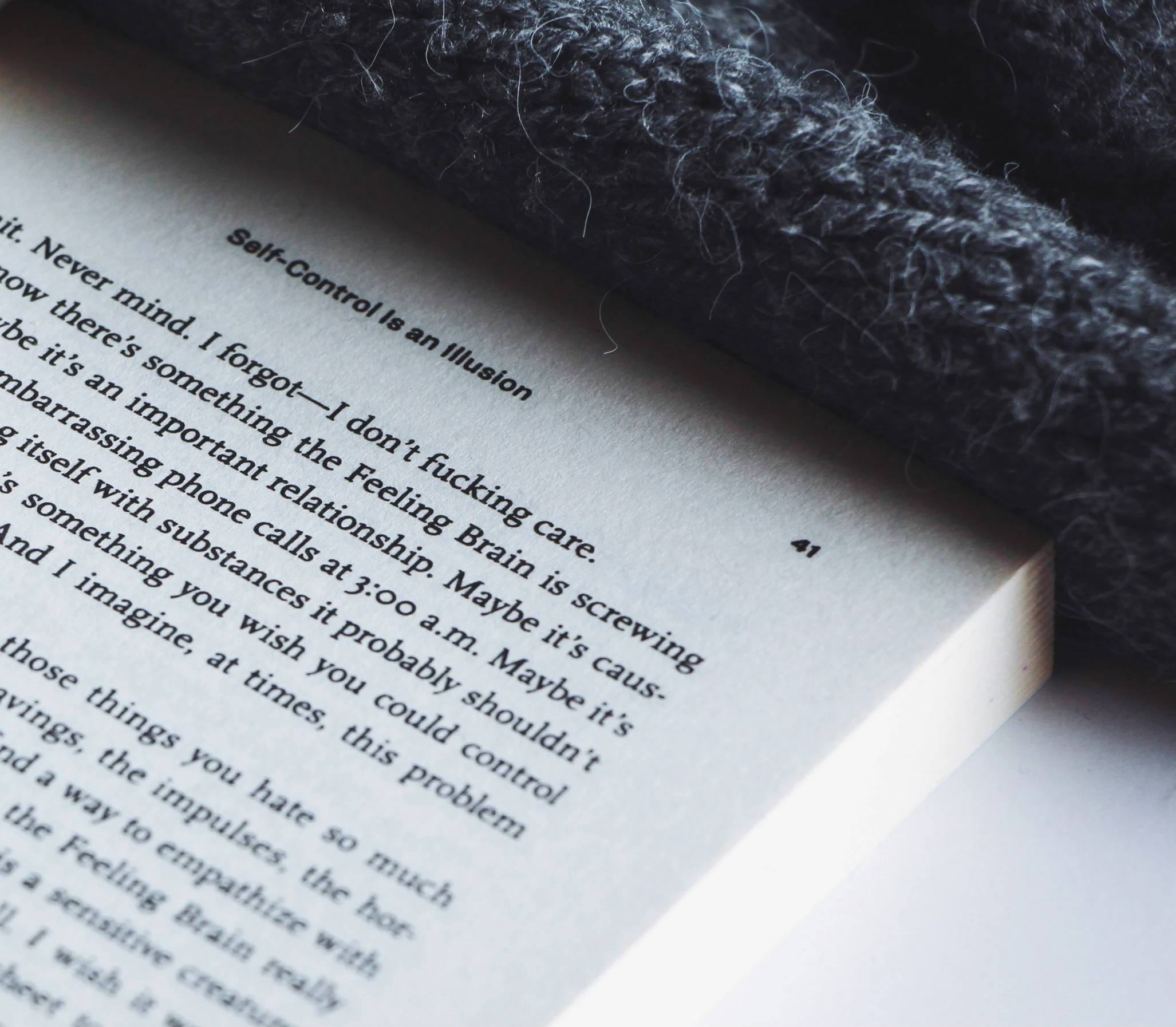 an open book and a black blanket on a table