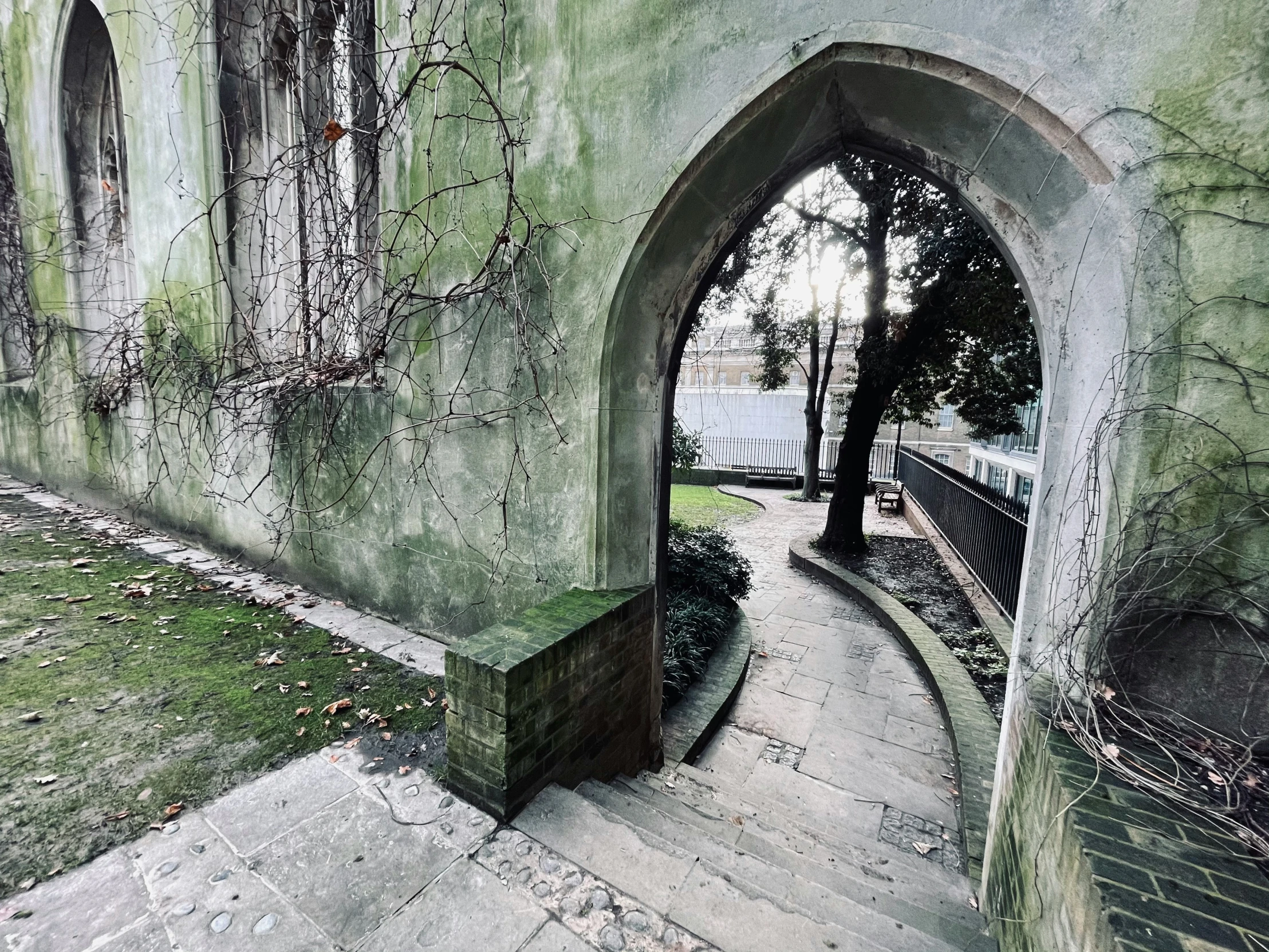 a building with an open walkway and a stone wall