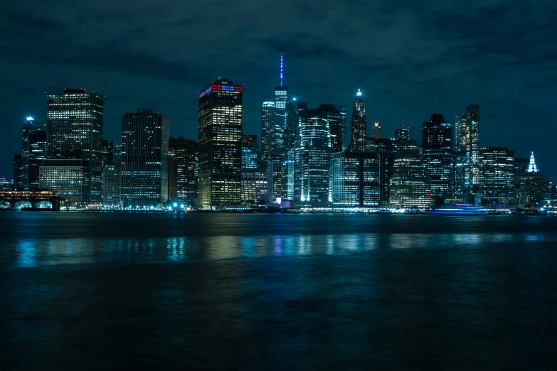 a nighttime cityscape with bright lights reflecting off the water