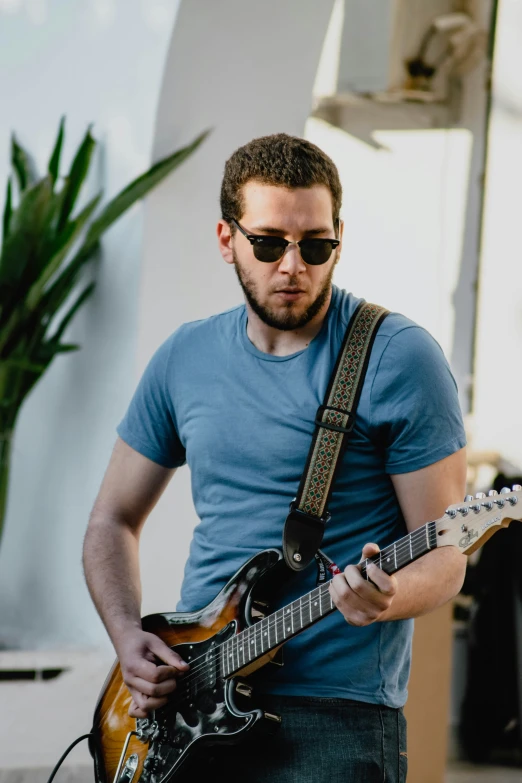 a man playing guitar in front of a building