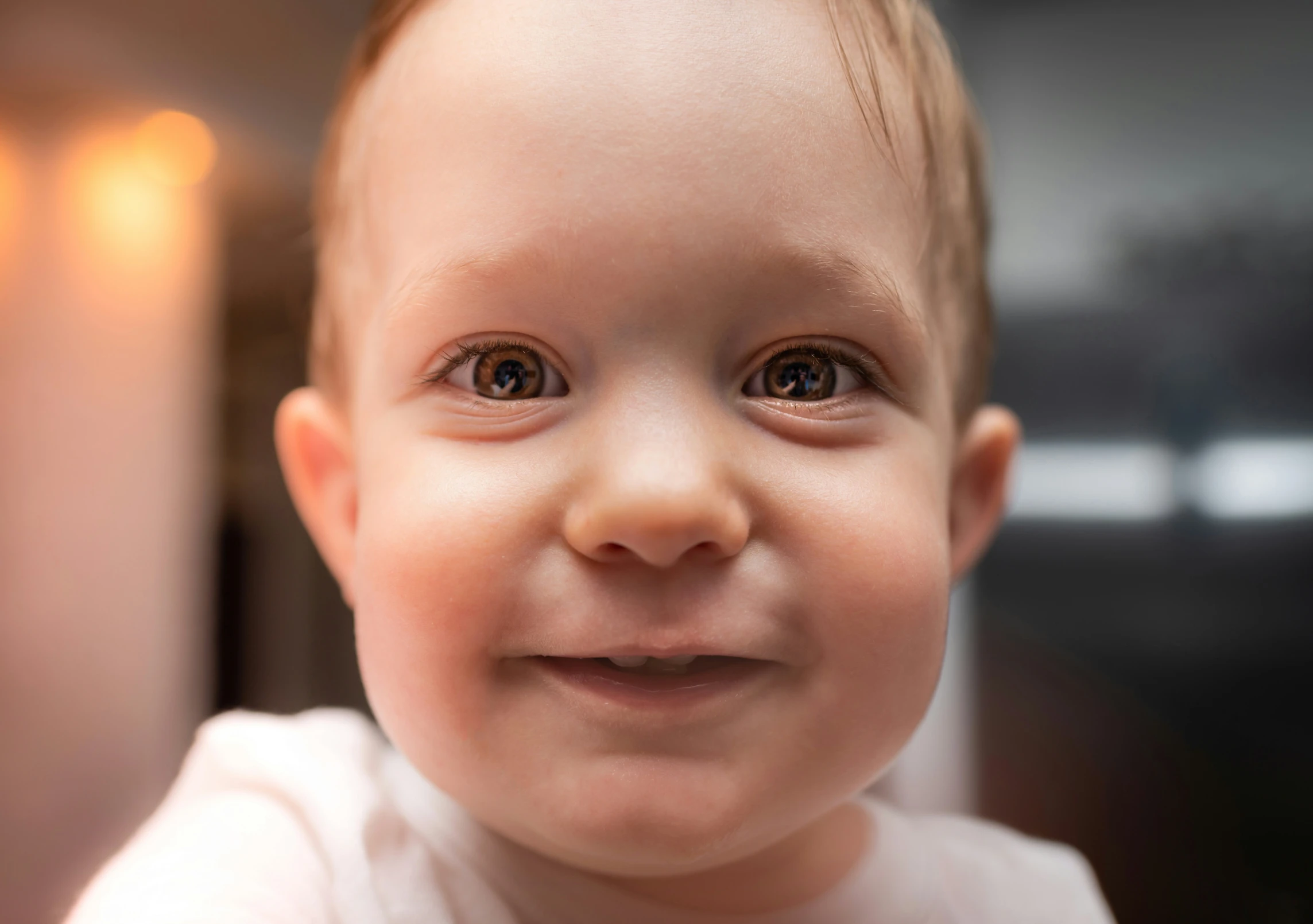 a baby is smiling and wearing a white shirt