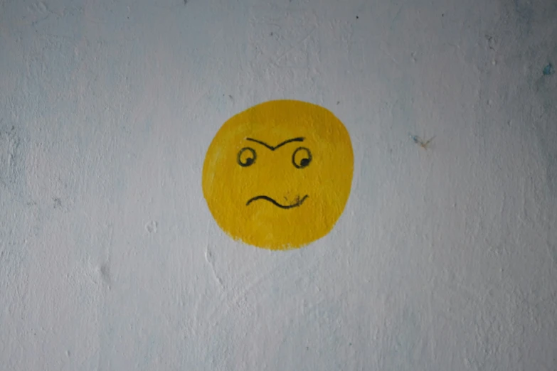 yellow round smiley face with frowning face drawn on it