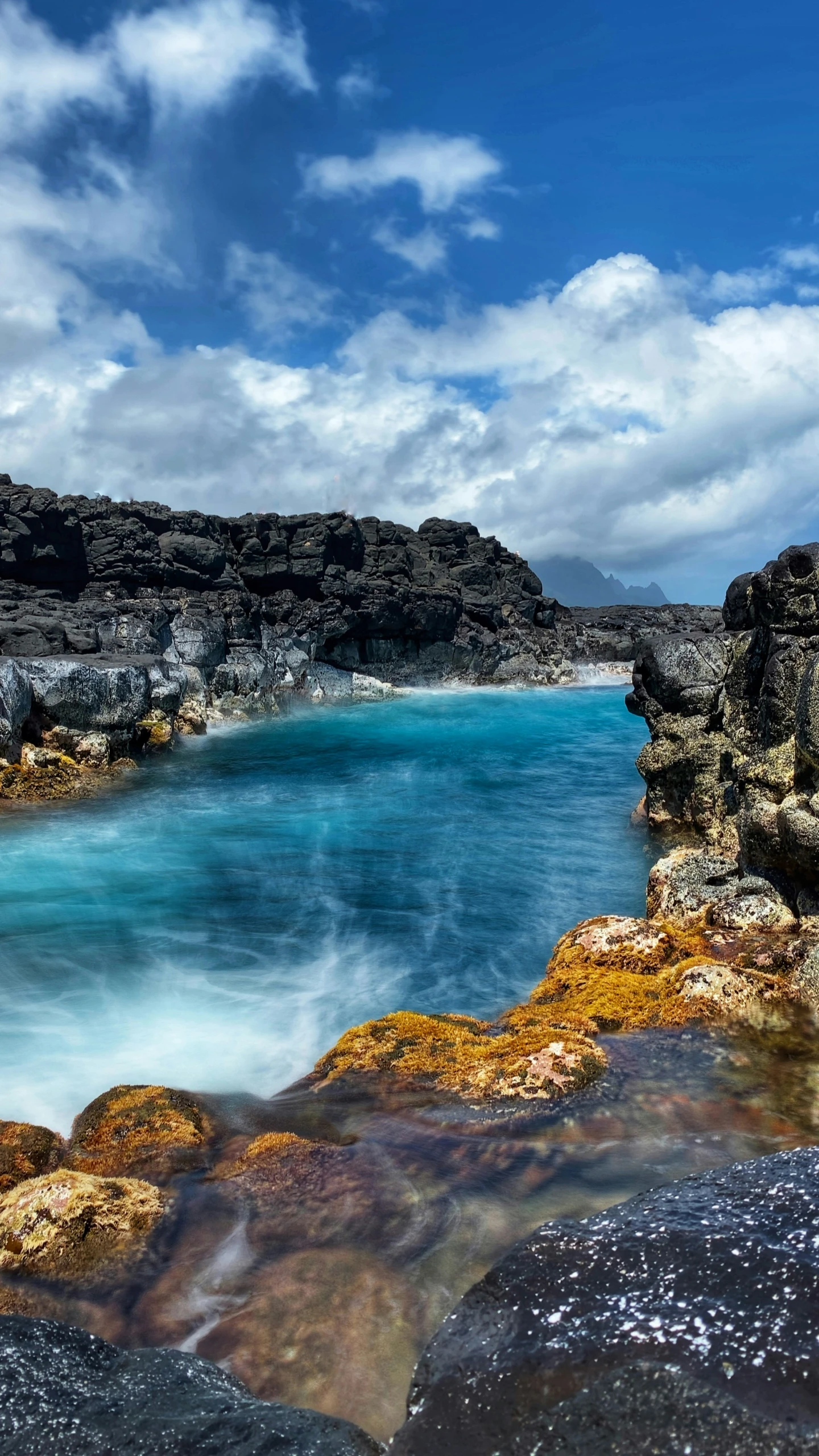 the shoreline of the water in front of the cliff