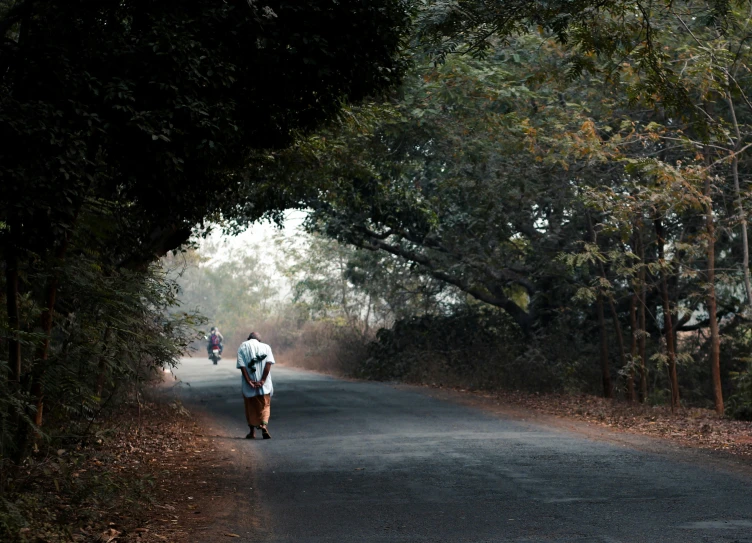 a group of people are running down a forest road