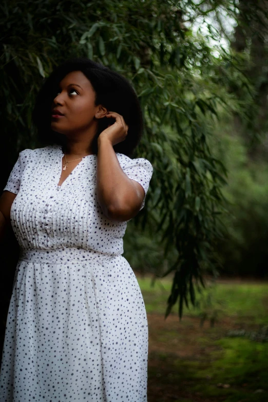 a woman is posing with her hands in her hair