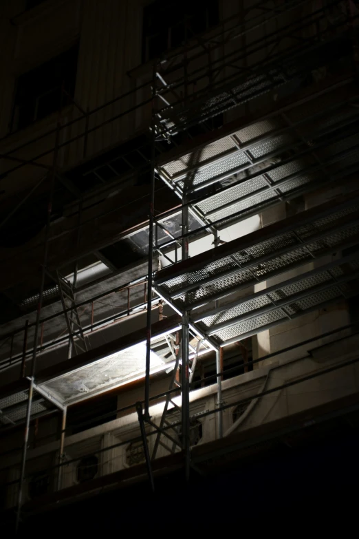 the light shines on a scaffolding and the building below