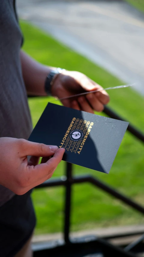 a person is holding up a passport and walking along the railing