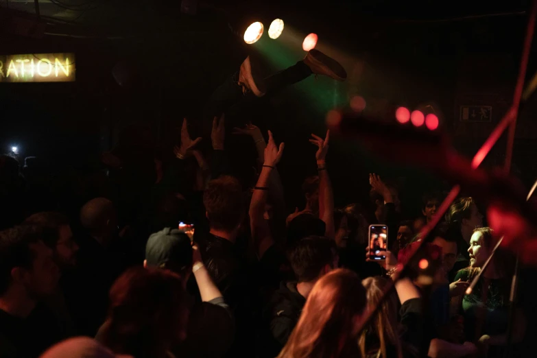 an audience clapping to their cell phone at a concert