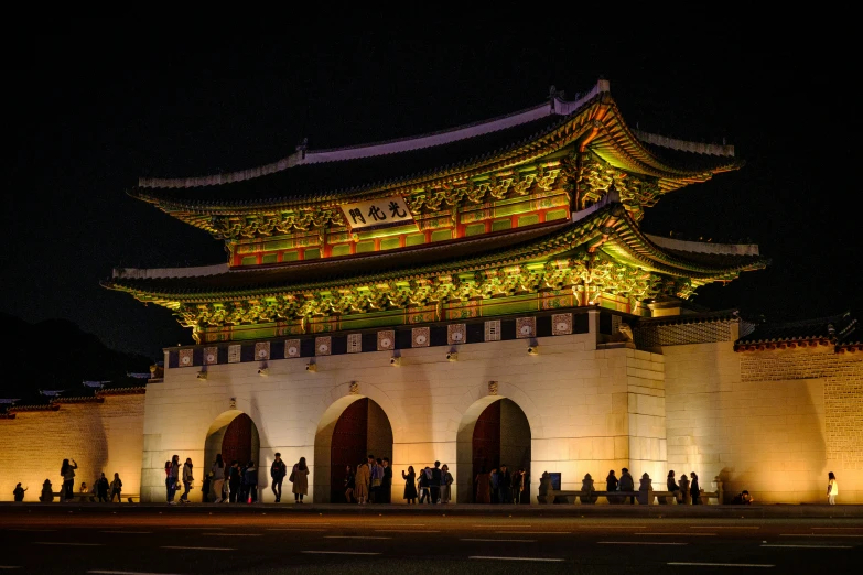 people standing outside a building with the light on