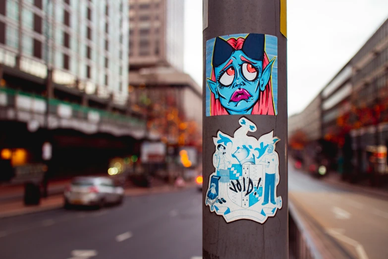 an image of graffiti on a pole near the street
