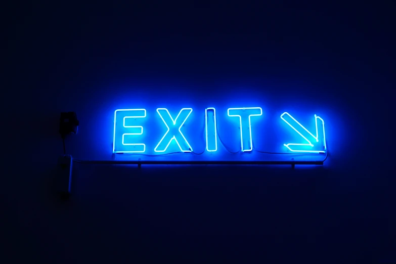 illuminated exit sign in dark room with dark background