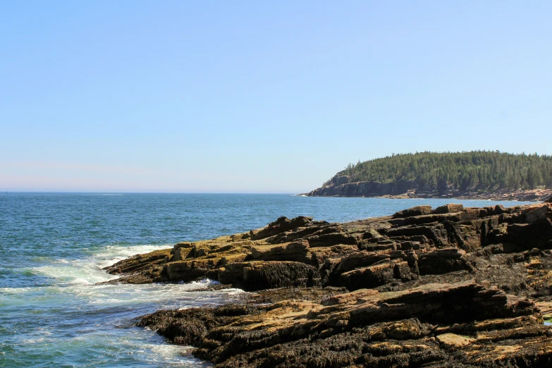 a sea stack is on the shore next to the ocean