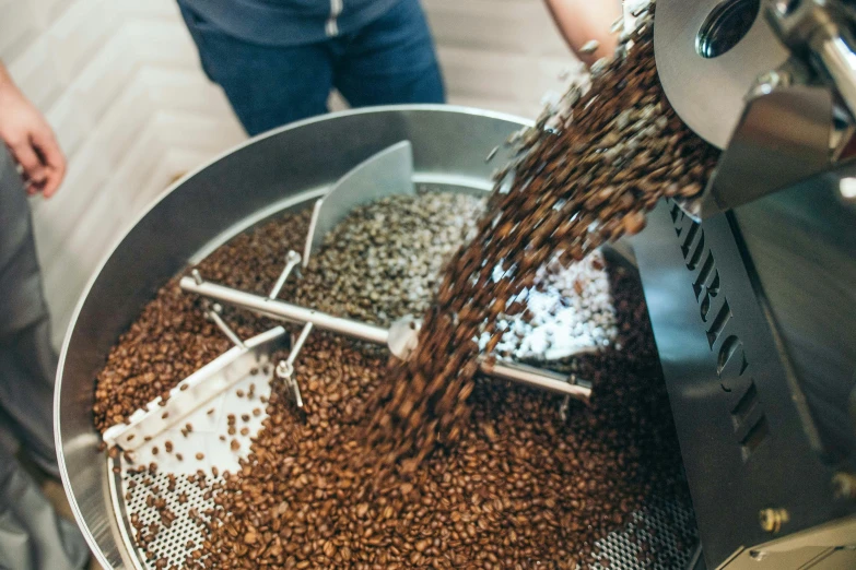 a person pouring coffee into a metal container