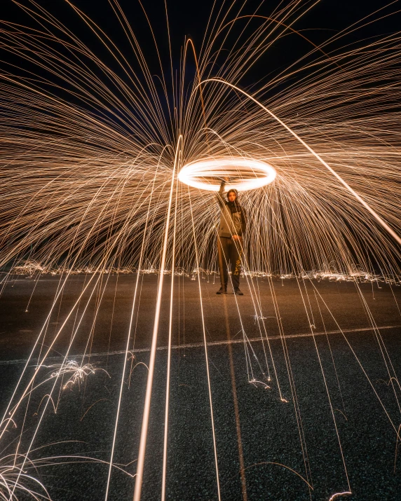 the man is on the side of the street while looking at a firework