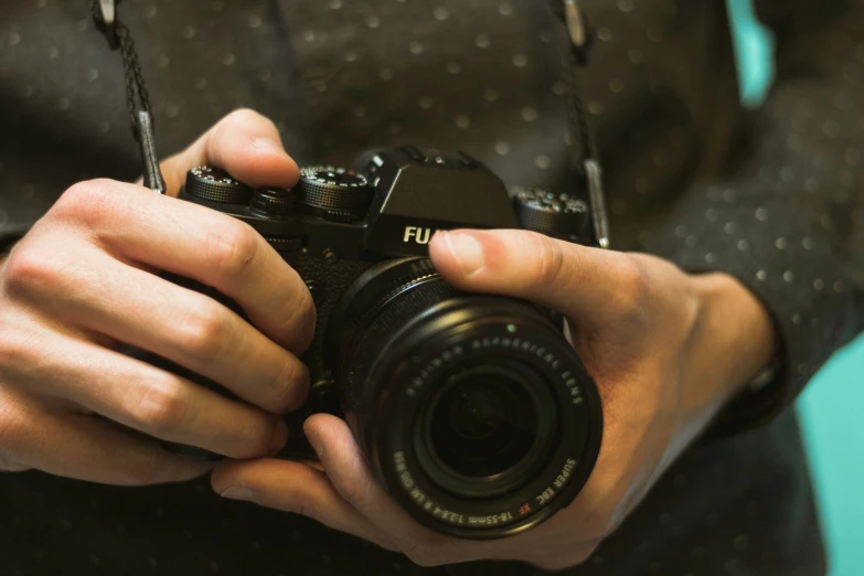 a person holding a camera in front of a lens