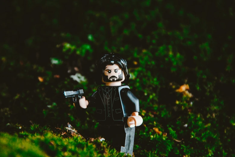 a toy figure with black paint holds a gun