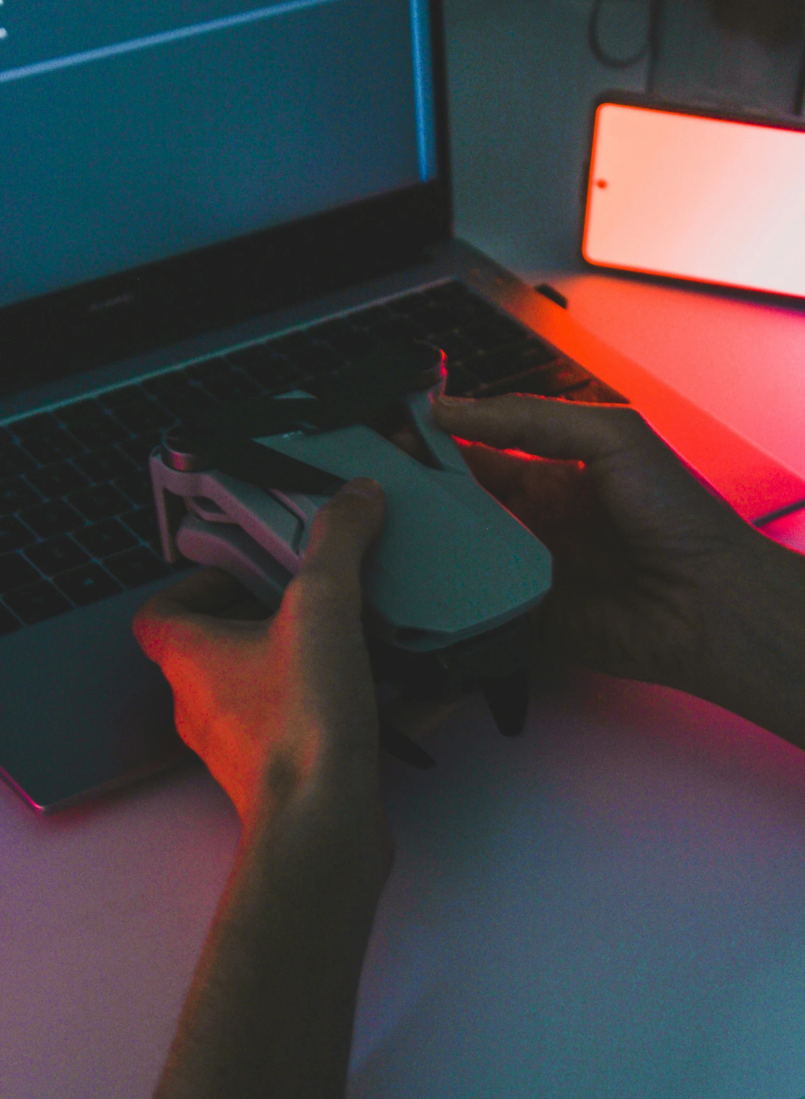 person's hand holding a mouse as they play on a laptop