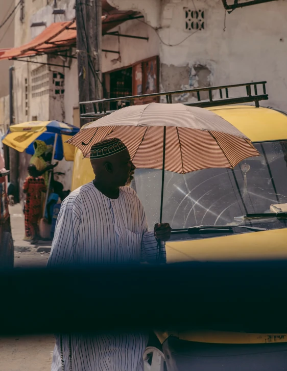 a man in striped shirt holding an open umbrella