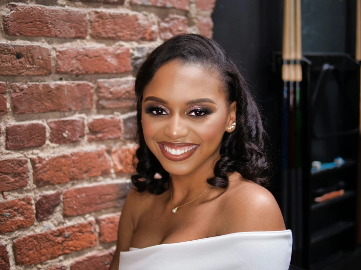 a woman wearing gold eyeshades in front of a brick wall