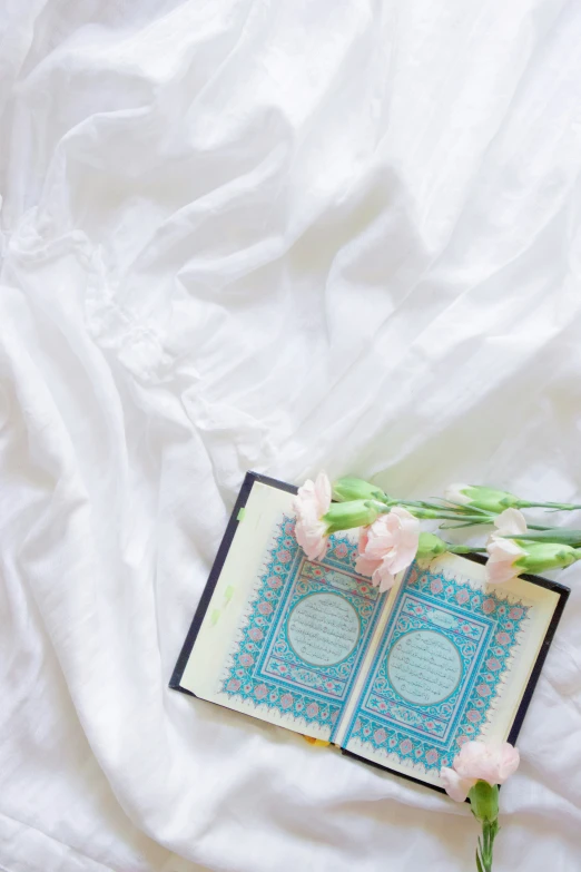 a book is sitting on top of an open book with flowers