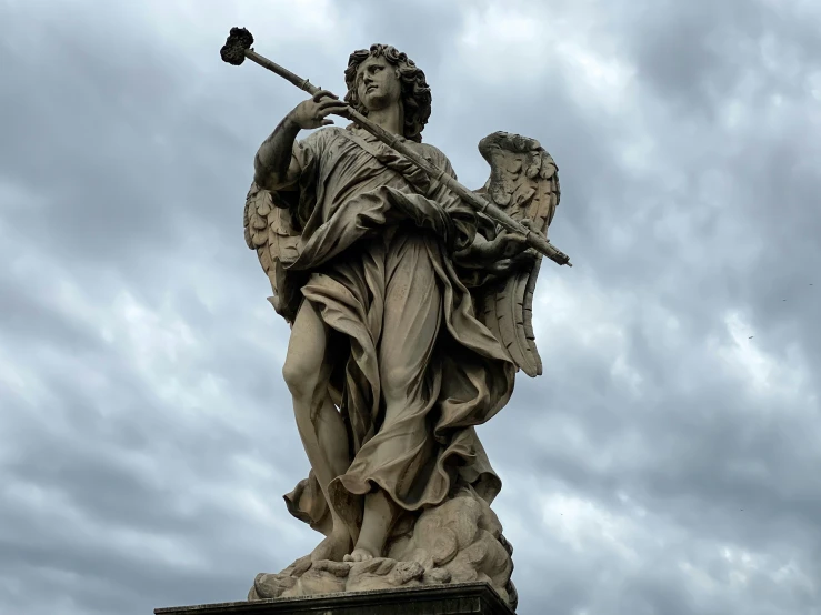the statue is holding a gun near some clouds