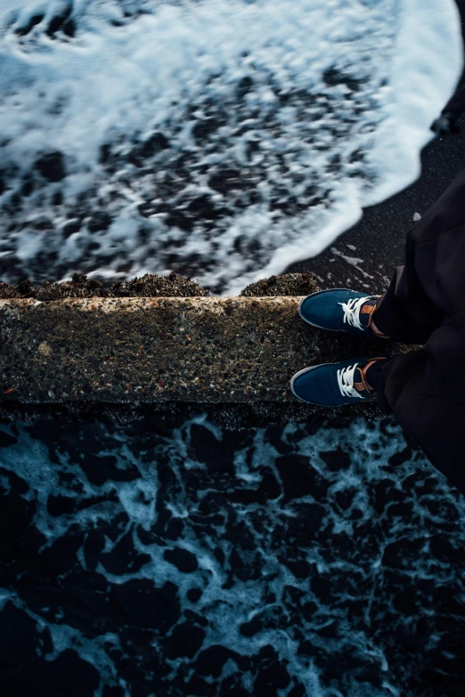 someone standing on a sidewalk near some ocean