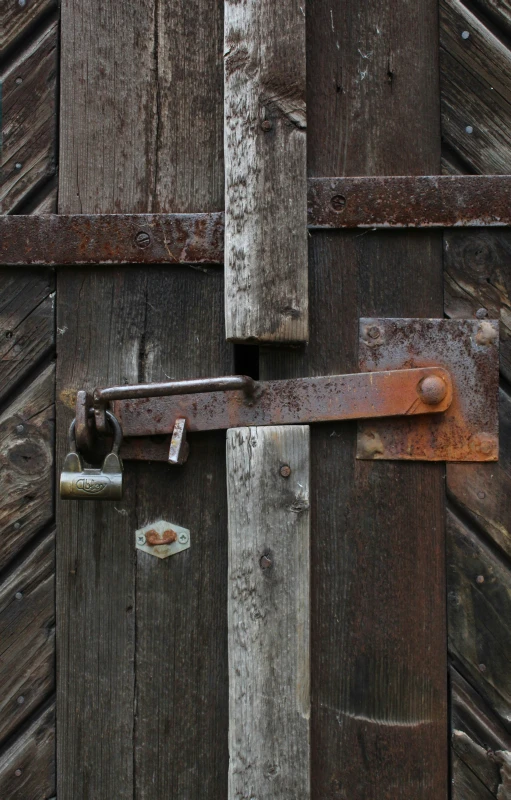 a rusted steel door handle attached to a wooden door