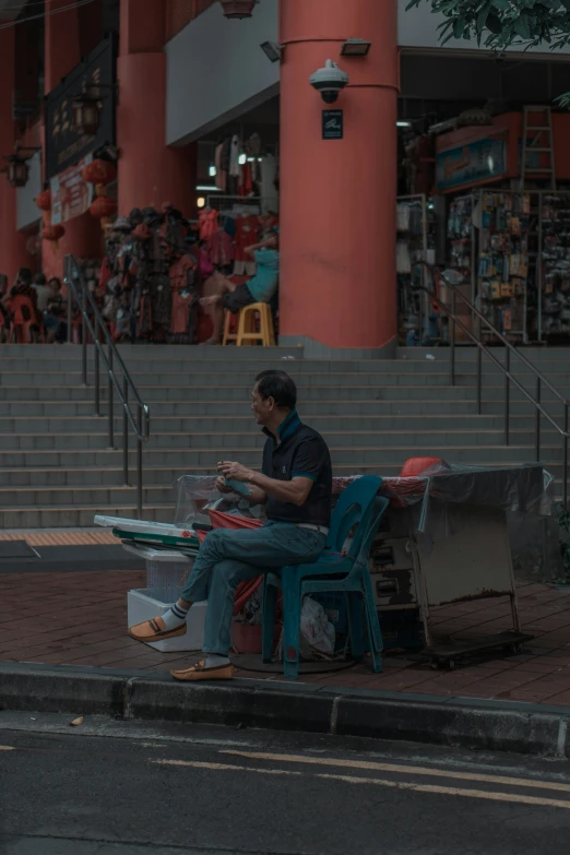 a man sitting on a bench next to a bunch of books