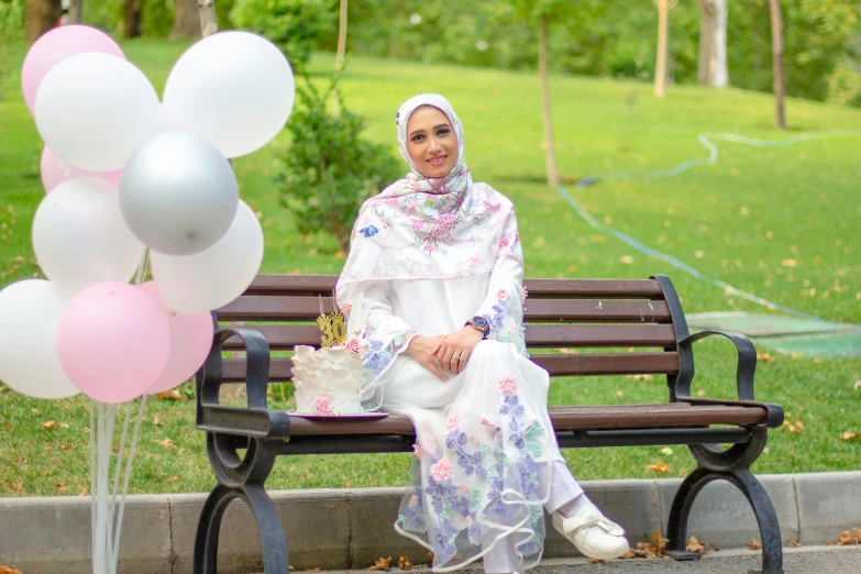 a woman in white sits on a park bench