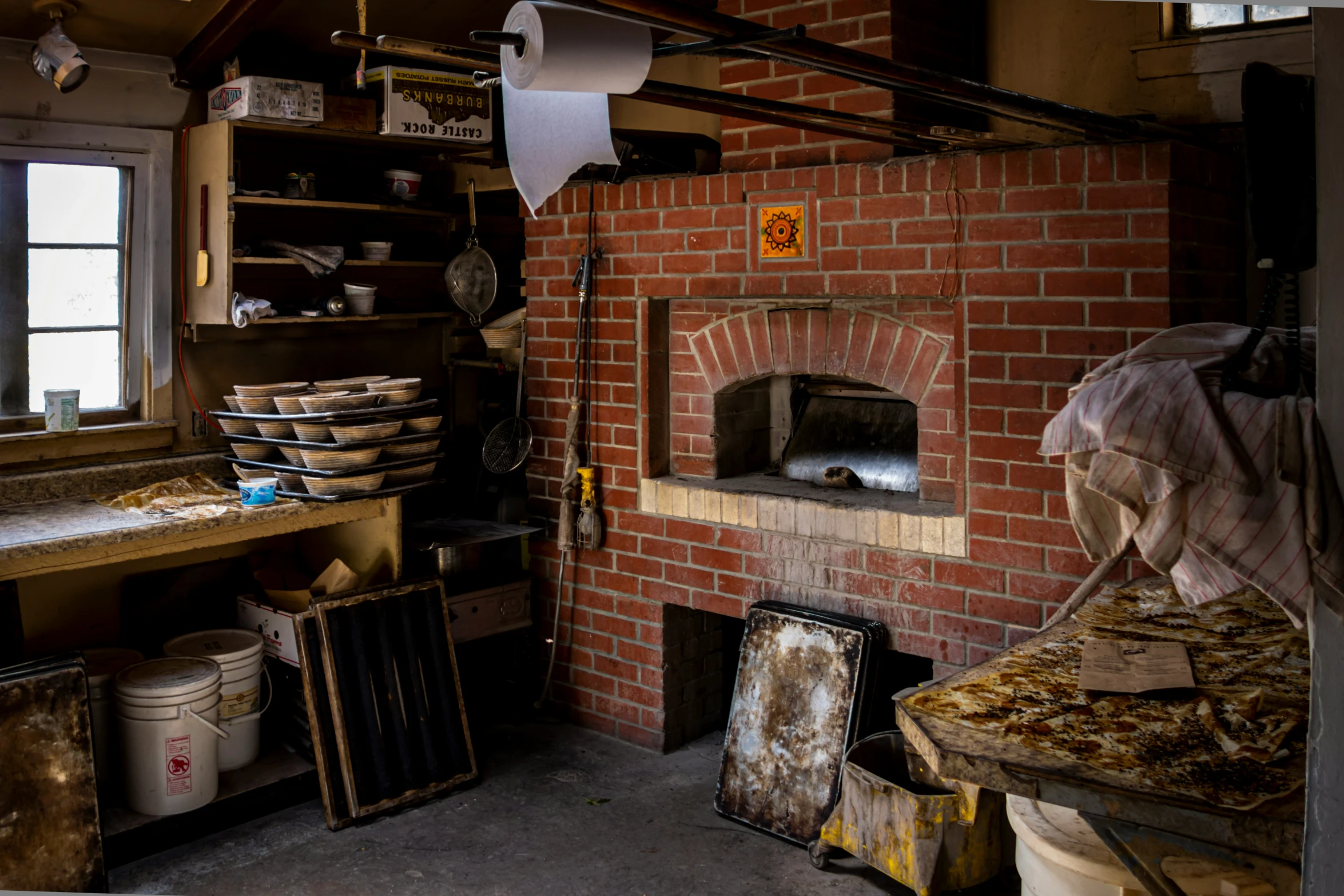 this kitchen has a stone oven and shelves filled with various dishes