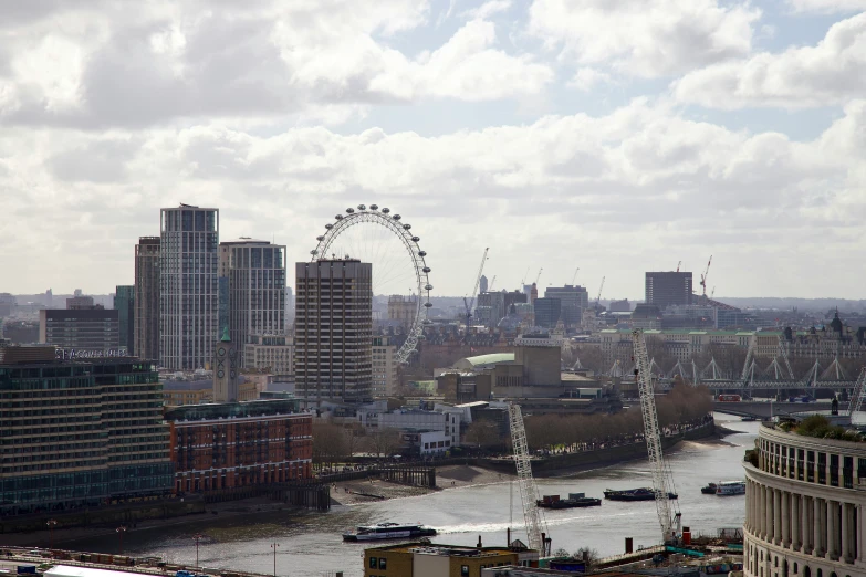 a city from the top of a building looking out at a large ferris wheel