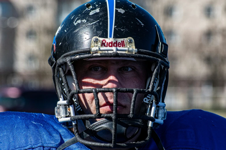 a male with a helmet on that is standing in the field