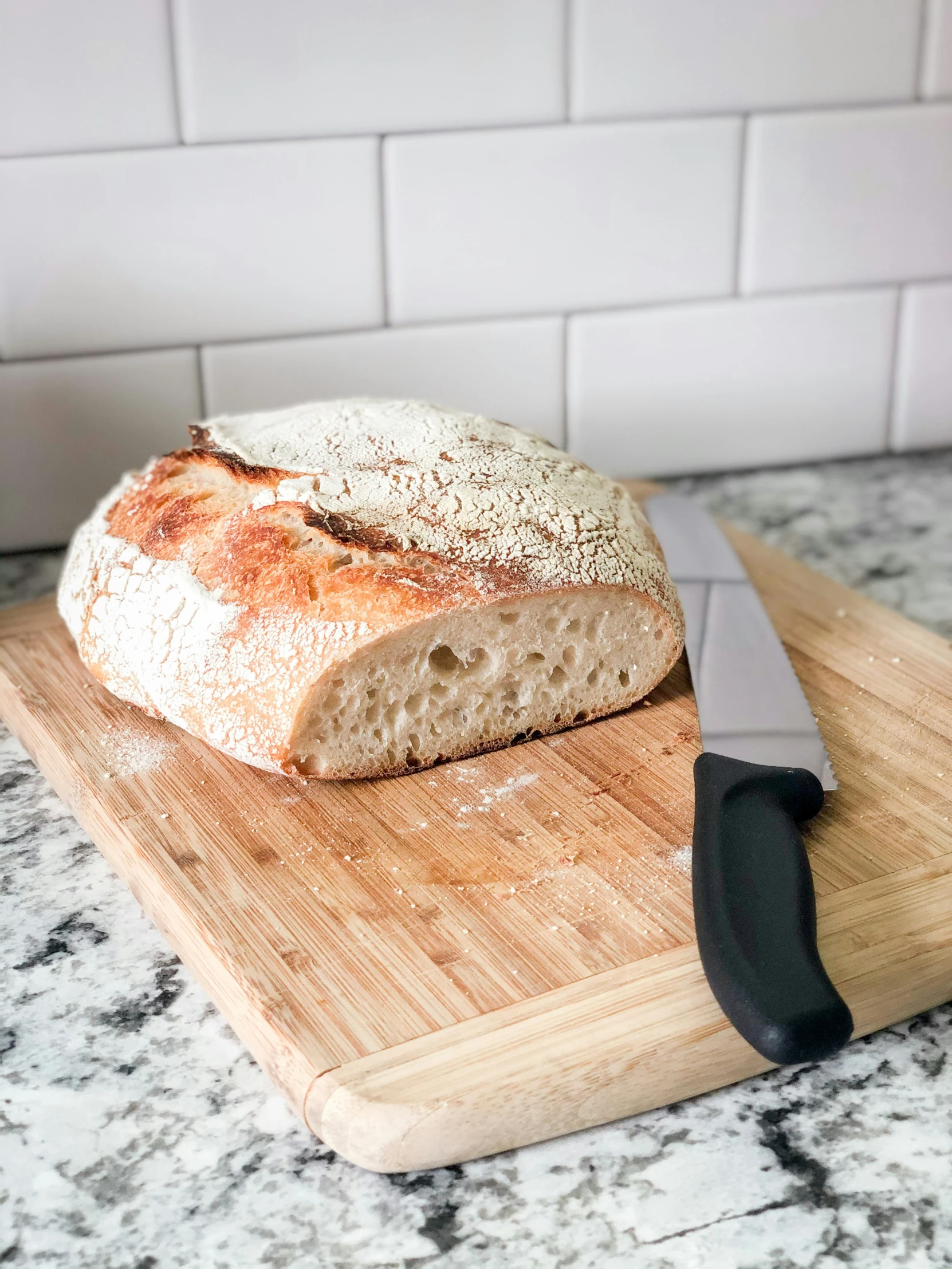 bread on a  board next to a knife