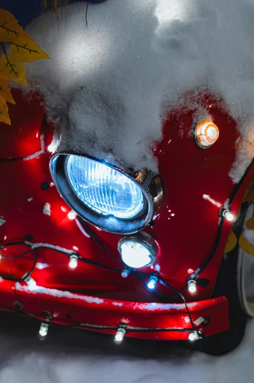 a closeup s of the front grille of a vintage car that is covered in snow