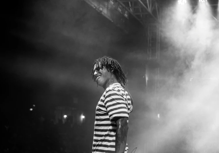 a male on stage with a microphone and lights in the background