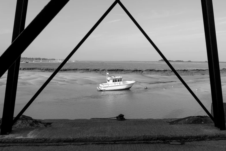 boat in the water under a bridge near shore