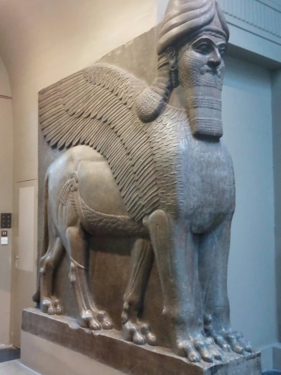 ancient statue displayed in front of wall in large hall