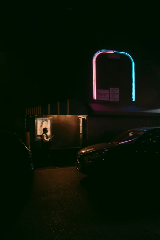 a car parked by a building with neon light