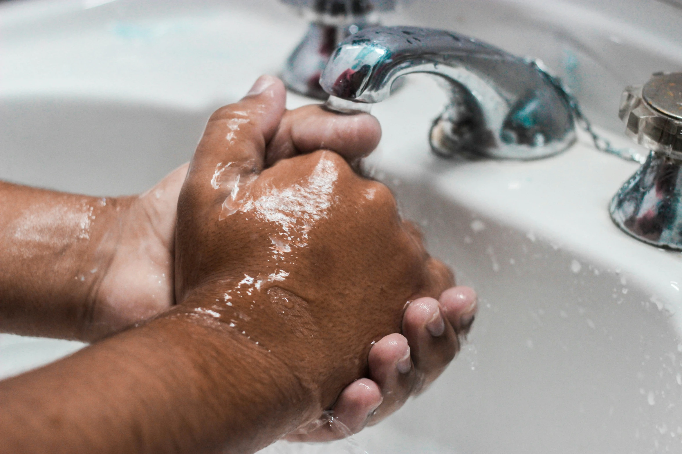 a man washing his hands with soap on the sink