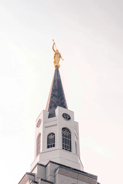 the spire of a church with a golden statue on top