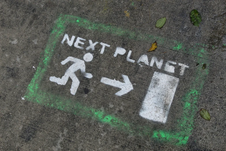 an exit sign painted on asphalt with green border