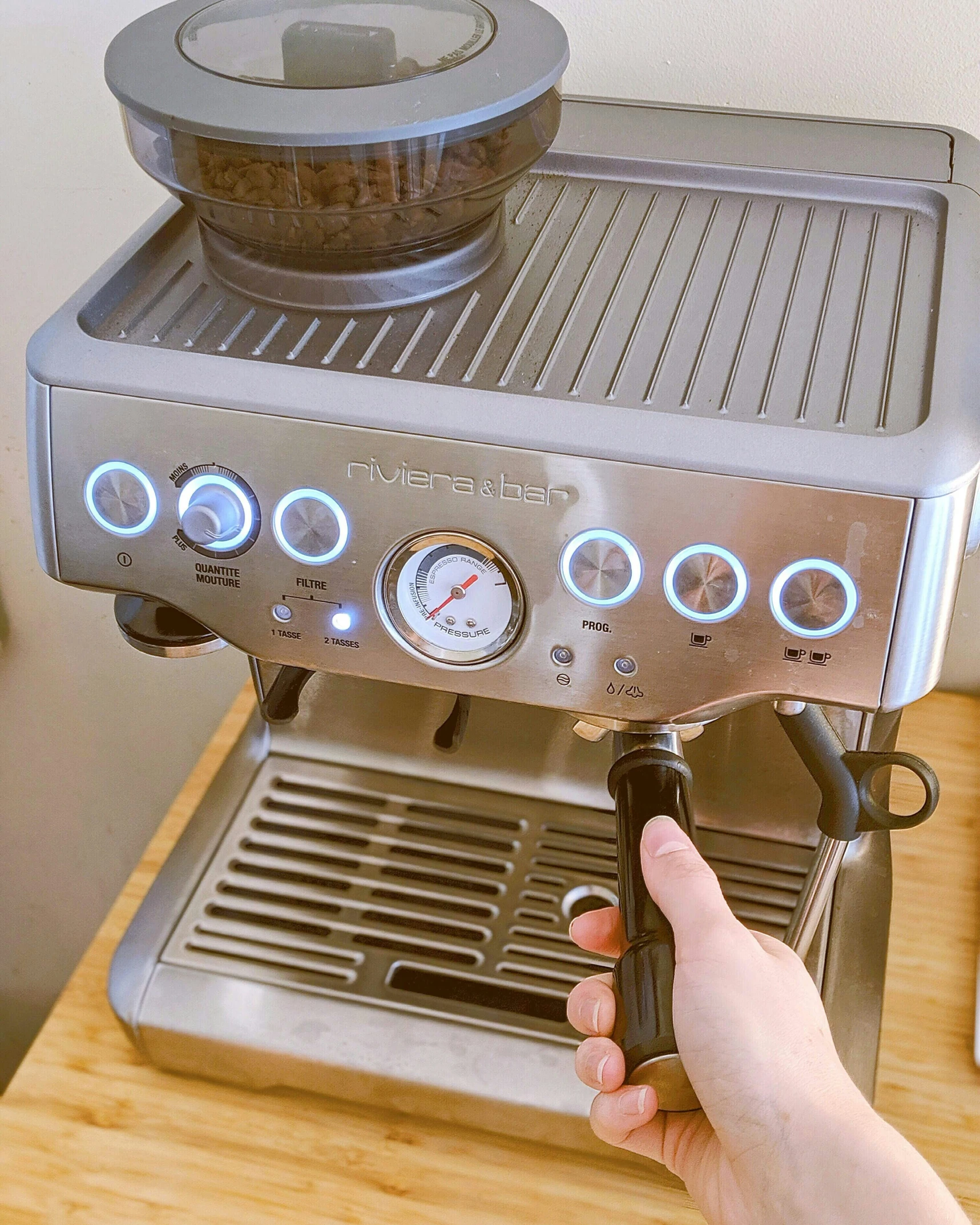 a person's hand is holding a machine with multiple burners