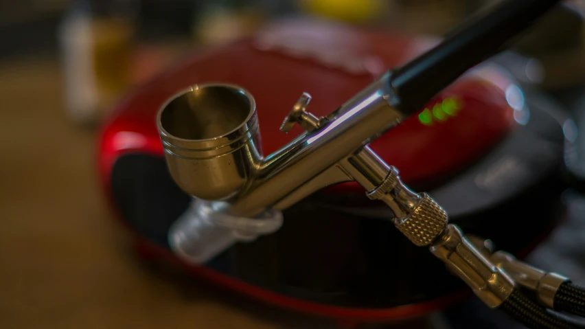 a metal bowl containing a small cigarette and a glass tube