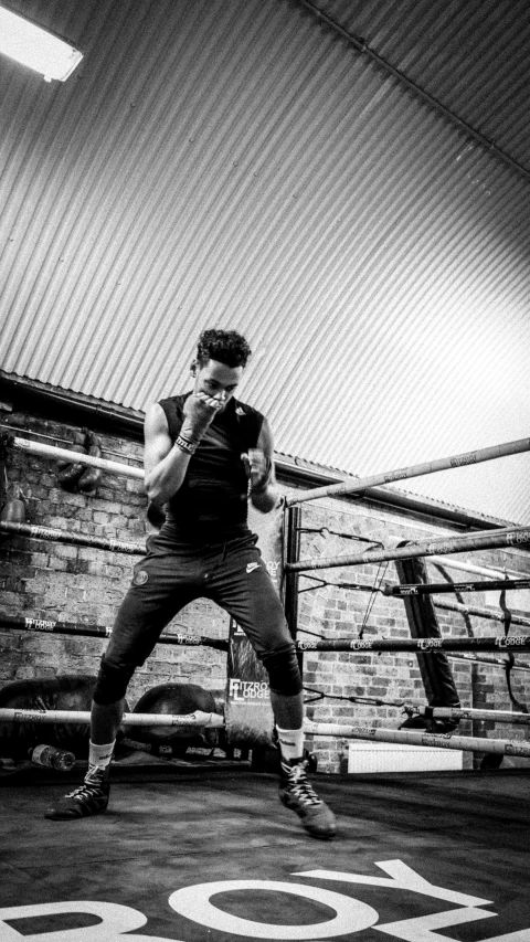 a person on a cell phone while standing in a boxing ring